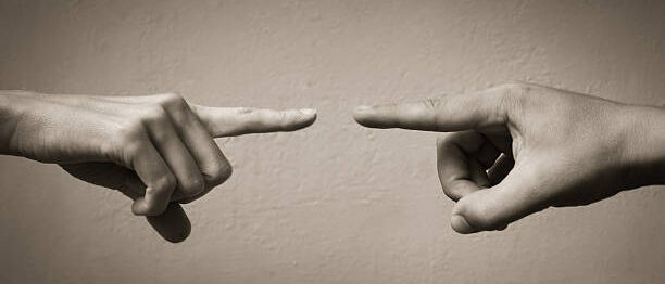 hands pointing fingers at each other. blame concept.